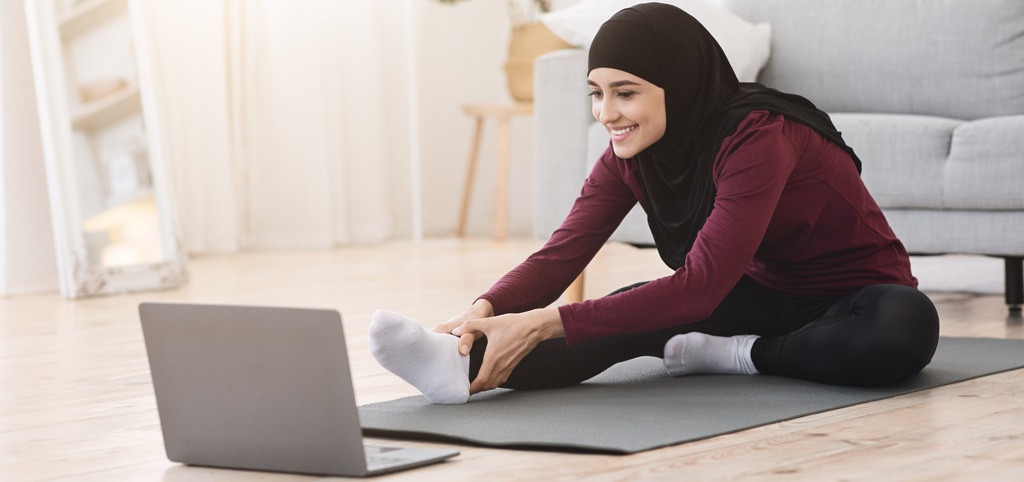 Self care - woman stretching in front of her laptop